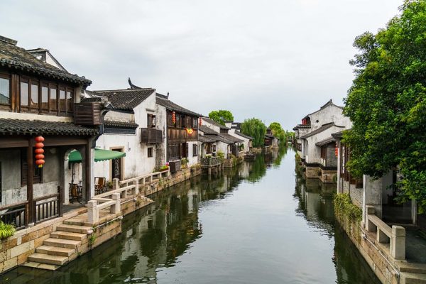 A canal in the ancient town of Dangkou, Jiangsu Province. Both sides of the canal are lined with traditional two-story white houses with verandas, wooden windows and black-tiled roofs.