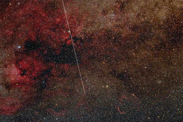 A wide-field image of stars with a white coordinate line illustrates the position of the low Earth orbit Tiangong Space Station.