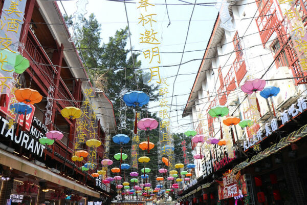 Dozens of colorful lanterns and festive neon greetings have been strung together to form a bright canopy over a street lined with restaurants and bars in the popular tourist destination of Yangshuo, in China’s Guangxi province.